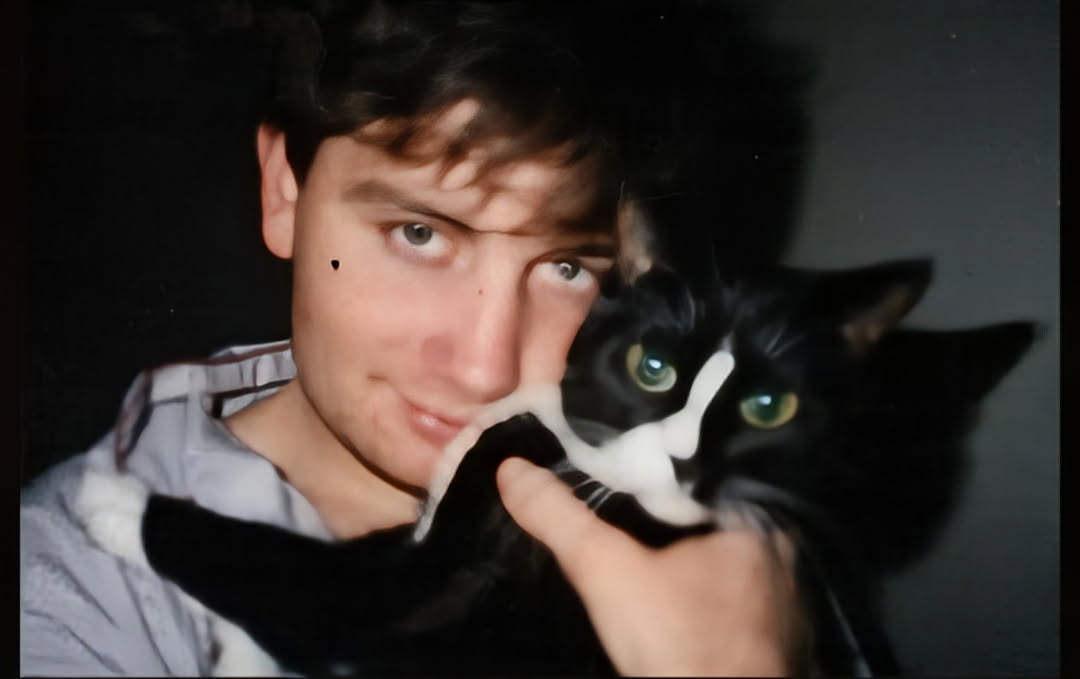 Al-Antony Moody holding a black and white cat